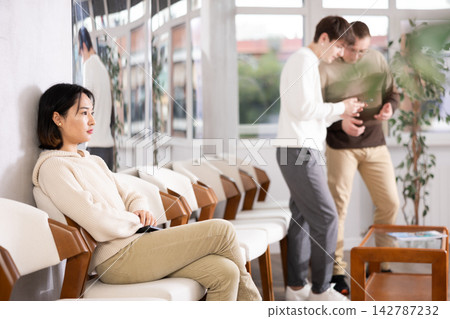 Young woman sitting in line at reception 142787232