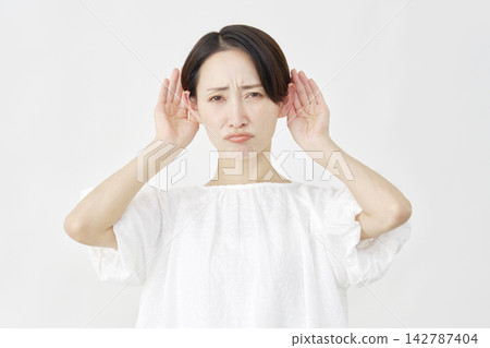 一位中年婦女擺出聆聽的姿勢，神情憂慮，背景為白色。 142787404