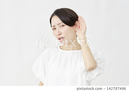 A middle-aged woman in a listening pose, looking troubled, against a white background. A middle-aged woman in a listening pose, looking troubled, against a white background. 142787406