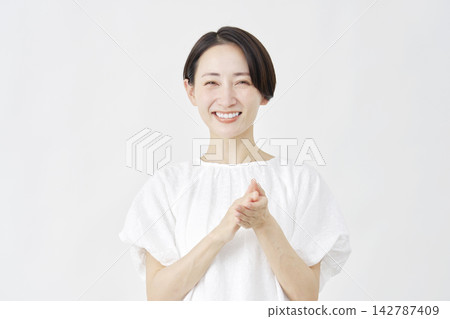 Middle-aged woman applauding against a white background. Middle-aged woman applauding against a white background. 142787409