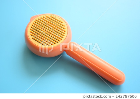 pastel orange comb on blue background, hair brush for pet pastel orange comb on blue background, hair brush for pet 142787606