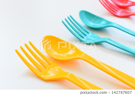 colorful spoon and fork isolated on white background, plastic cutlery for picnic 142787607