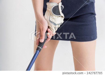 一雙女人的手握著一支高爾夫球桿 一雙女人的手握著一支高爾夫球桿 142787785