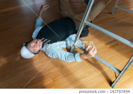 一名男工人從梯子上摔了下來。 一名男工人從梯子上摔了下來。 142787894