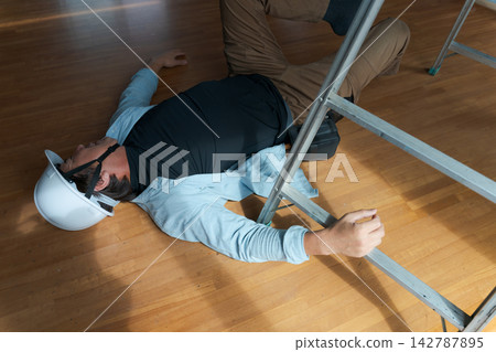 一名男工人從梯子上摔了下來。 一名男工人從梯子上摔了下來。 142787895