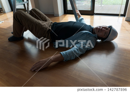 一名男工人從梯子上摔了下來。 一名男工人從梯子上摔了下來。 142787896