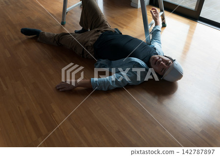 一名男工人從梯子上摔了下來。 一名男工人從梯子上摔了下來。 142787897