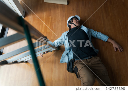 一名男工人從梯子上摔了下來。 一名男工人從梯子上摔了下來。 142787898