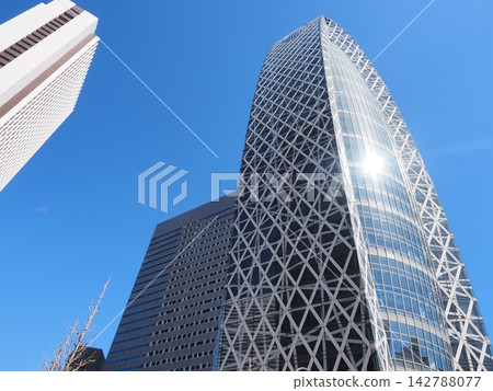 Mode Gakuen Cocoon Tower stands tall against the blue sky in Shinjuku, Tokyo. 142788077