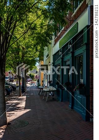 Charming main street and storefronts with parked cars in downtown Madison Connecticut Charming main street and storefronts with parked cars in downtown Madison Connecticut 142788211