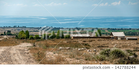 Distant view of Issyk Kul lake and rural settlement Kyrgyzstan Distant view of Issyk Kul lake and rural settlement Kyrgyzstan 142788244