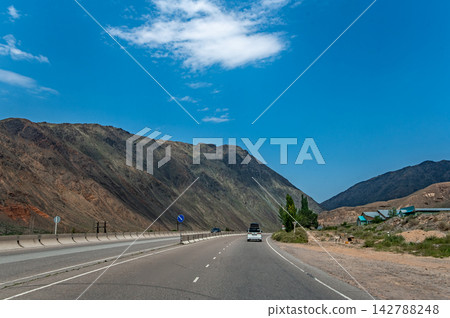 Highway driving from Issyk Kul toward Bishkek through mountain landscapes Kyrgyzstan Highway driving from Issyk Kul toward Bishkek through mountain landscapes Kyrgyzstan 142788248