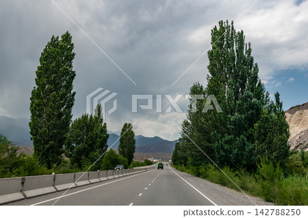 Highway driving from Issyk Kul toward Bishkek through mountain landscapes Kyrgyzstan Highway driving from Issyk Kul toward Bishkek through mountain landscapes Kyrgyzstan 142788250