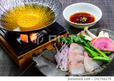 享用這道鯛魚涮涮鍋(鯛魚涮涮鍋),新鮮的鯛魚和蔬菜蘸著湯汁食用。 享用這道鯛魚涮涮鍋(鯛魚涮涮鍋),新鮮的鯛魚和蔬菜蘸著湯汁食用。 142788276
