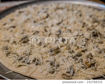 Uncooked white clam pie pizza on metal pan Uncooked white clam pie pizza on metal pan 142788335