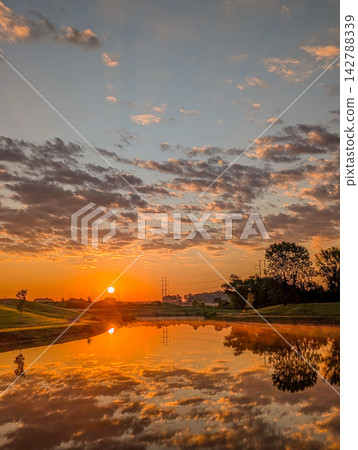 Golden sunset reflection on calm pond in Huntsville Alabama Golden sunset reflection on calm pond in Huntsville Alabama 142788339