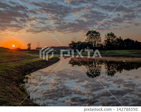 Golden sunset reflection on calm pond in Huntsville Alabama Golden sunset reflection on calm pond in Huntsville Alabama 142788350