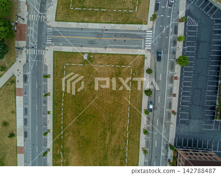 Aerial top down view of city streets grass lot parking Aerial top down view of city streets grass lot parking 142788487