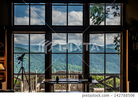 Mountain view through large cabin windows with telescope and desk North Carolina Mountain view through large cabin windows with telescope and desk North Carolina 142788506