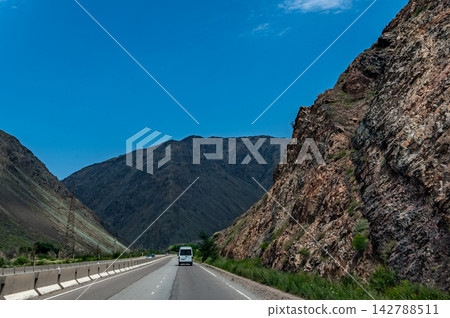 Highway driving from Issyk Kul toward Bishkek through mountain landscapes Kyrgyzstan Highway driving from Issyk Kul toward Bishkek through mountain landscapes Kyrgyzstan 142788511