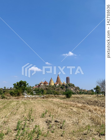 A temple amidst a blue sky and white clouds, as seen from a cafe in Thailand. A temple amidst a blue sky and white clouds, as seen from a cafe in Thailand. 142788636