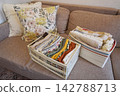 Organized Living Space with Soft Fabrics, Decorative Pillows, and Colorful Storage Solutions 142788713