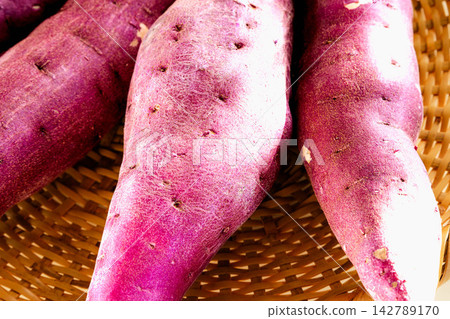A scene of delicious-looking sweet potatoes, a taste of autumn, sitting on a basket. A scene of delicious-looking sweet potatoes, a taste of autumn, sitting on a basket. 142789170