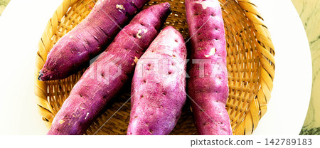 A scene of delicious-looking sweet potatoes, a taste of autumn, sitting on a basket. A scene of delicious-looking sweet potatoes, a taste of autumn, sitting on a basket. 142789183