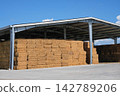 Hay barn with stacked bales for agricultural storage 142789206
