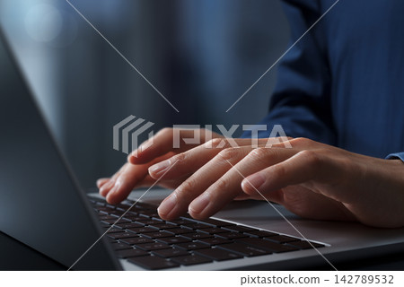 商務人士在辦公桌前使用筆記型電腦。特寫鏡頭:雙手和鍵盤。 商務人士在辦公桌前使用筆記型電腦。特寫鏡頭:雙手和鍵盤。 142789532