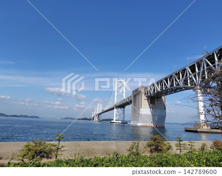 一張美麗的遠景照片,展現了雄偉的瀨戶大橋,它筆直地橫跨蔚藍的瀨戶內海。 一張美麗的遠景照片,展現了雄偉的瀨戶大橋,它筆直地橫跨蔚藍的瀨戶內海。 142789600