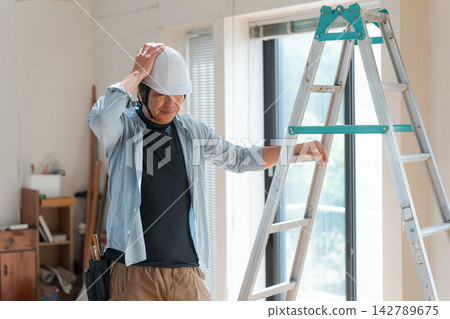一位表情憂慮的男工人。 142789675