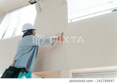 Male worker repairing a wall Male worker repairing a wall 142789847