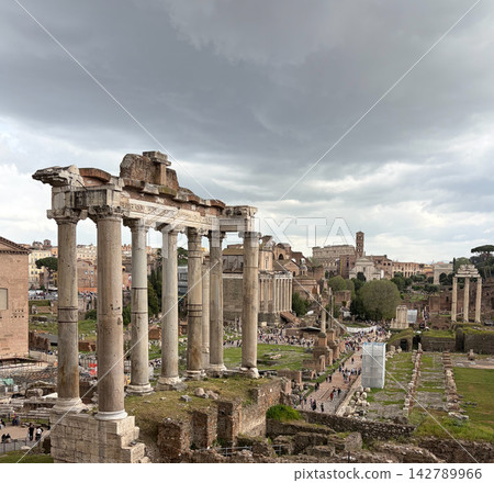 View of the Temple of Saturn and the Colosseum at the Roman Forum in Rome, Italy. View of the Temple of Saturn and the Colosseum at the Roman Forum in Rome, Italy. 142789966