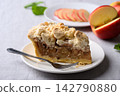 Apple crumble pie slice on white plate with fork and fresh apple fruit 142790880