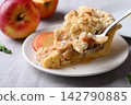 Eating apple crumble pie slice with caramel sauce on white plate and fresh apple fruit 142790885