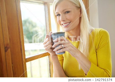 Happy woman, portrait and window with coffee for morning, drink or hot beverage at home. Attractive Female person or young blonde with smile for cappuccino, latte or americano in living room at house Happy woman, portrait and window with coffee for morning, drink or hot beverage at home. Attractive Female person or young blonde with smile for cappuccino, latte or americano in living room at house 142791374