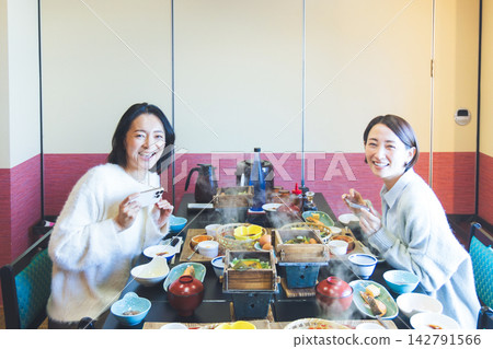 兩位中年婦女帶著笑容地在日本一家旅館享用早餐。 兩位中年婦女帶著笑容地在日本一家旅館享用早餐。 142791566