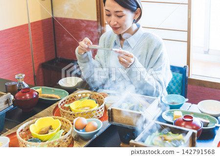 一位女士正開心地用智慧型手機拍攝她的餐點照片。 一位女士正開心地用智慧型手機拍攝她的餐點照片。 142791568