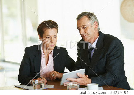 Tablet, office and mature business people for meeting with internet research, collaboration and planning strategy together. Financial advisor job, man and woman by desk with tech and feedback notes Tablet, office and mature business people for meeting with internet research, collaboration and planning strategy together. Financial advisor job, man and woman by desk with tech and feedback notes 142791941