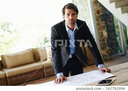 Portrait, businessman or manager with blueprint for planning, building design or floor plan on desk. Home office, architecture or male architect with paper for project renovation, real estate or idea Portrait, businessman or manager with blueprint for planning, building design or floor plan on desk. Home office, architecture or male architect with paper for project renovation, real estate or idea 142792094