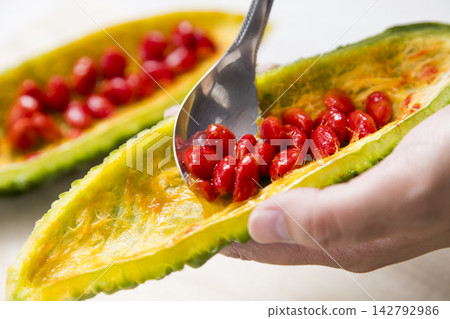 用湯匙去除紅色種子-準備過程。 用湯匙去除紅色種子-準備過程。 142792986