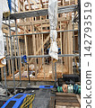 A new wooden house construction site; the house is still under construction with its columns and beams assembled. 142793519