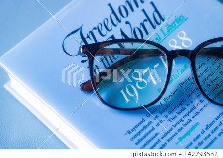 Reading - foreign books and magnifying glasses that make the text appear larger. 142793532