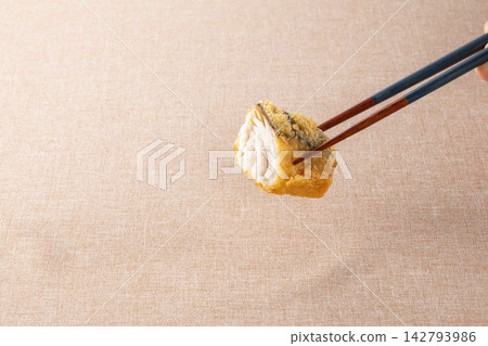 他正用筷子夾起炸好的西班牙鯖魚。 142793986