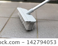 Clean the balcony tiles with a deck brush. 142794053