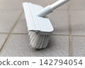 Clean the balcony tiles with a deck brush. 142794054