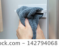 A housewife wipes her hands on the towel rack in the refrigerator. 142794068