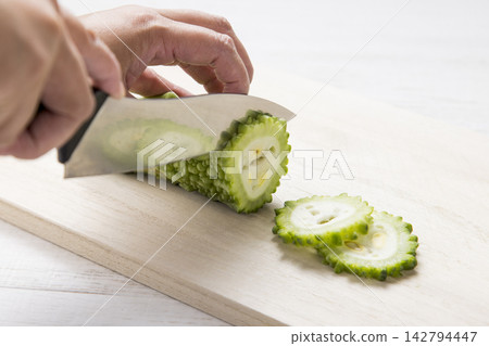 用刀將苦瓜切成片的手 142794447