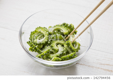 將苦瓜放入玻璃碗中,用鹽搓揉處理。 將苦瓜放入玻璃碗中,用鹽搓揉處理。 142794456